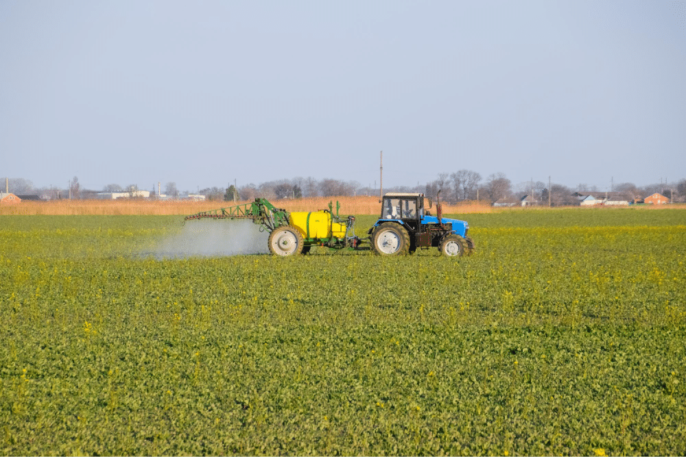 Tractor spraying in open field.